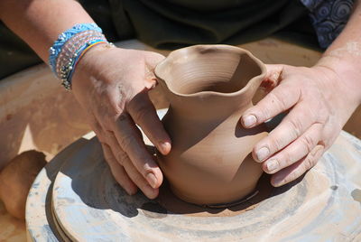 Cropped hand of potter making pot at workshop