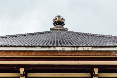 Low angle view of building roof against sky