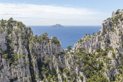 Scenic view of sea and mountains against sky