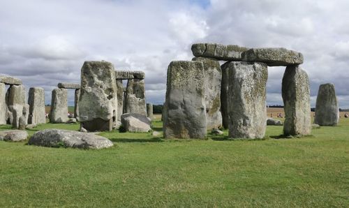 Old ruins on field against cloudy sky