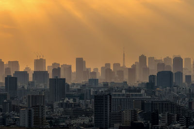 Modern buildings in city against sky during sunset