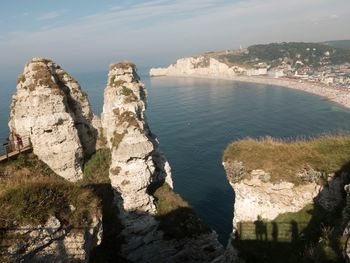 Scenic view of sea by cliff against sky