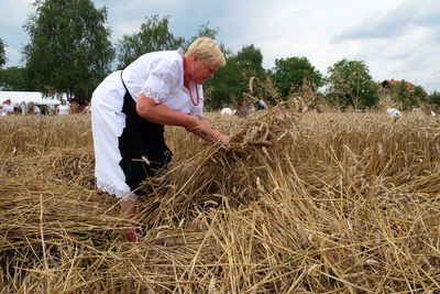 Midsection of woman in field against sky