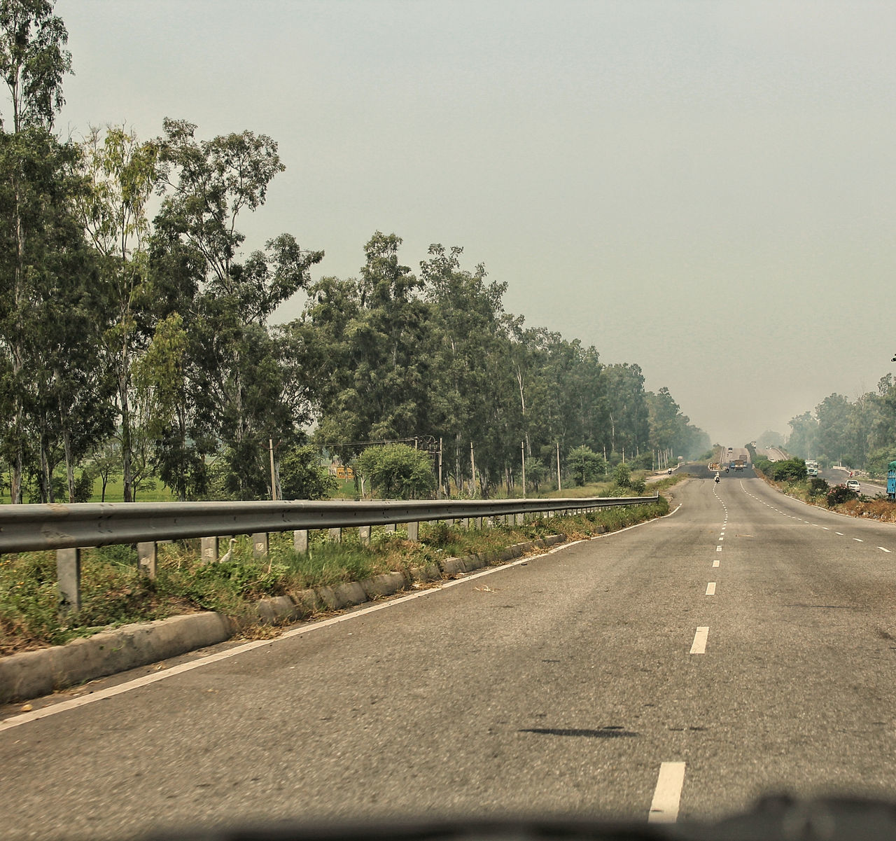 ROAD BY TREES AGAINST SKY SEEN THROUGH CAR WINDSHIELD