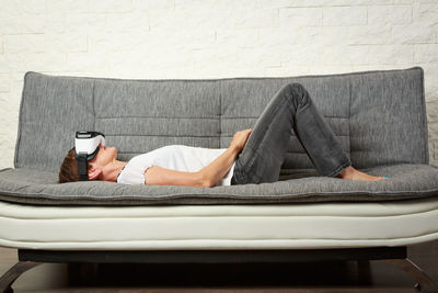 Side view of man lying on sofa