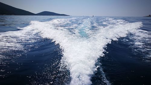 Waves splashing on sea against sky