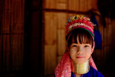 Portrait of a smiling young woman in long neck tribe traditional costume
