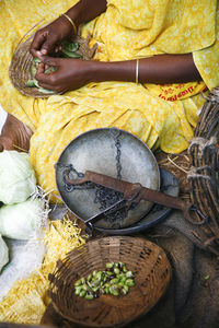 Midsection of woman selling beans in market