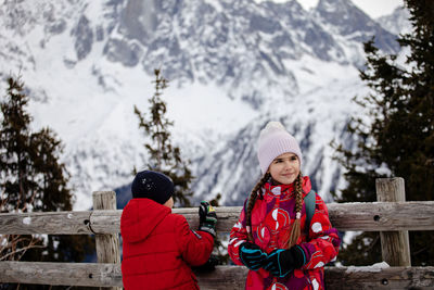 Sister and brother in the alps, boy captures moments, youth embracing winter wonders