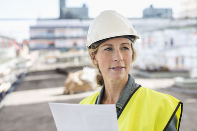 Female architect looking away while working at construction site