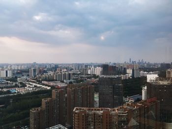 High angle view of cityscape against cloudy sky