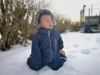 Cute baby girl on snow covered land