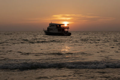 Boat sailing on sea against sky during sunset