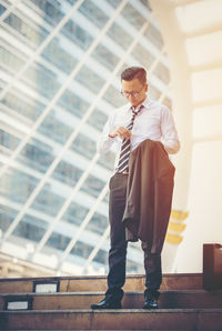 Full length of young man standing against building