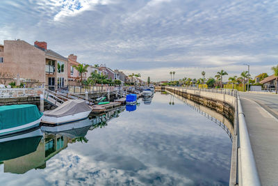 Panoramic view of canal amidst buildings against sky