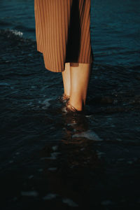 Midsection of woman standing in sea