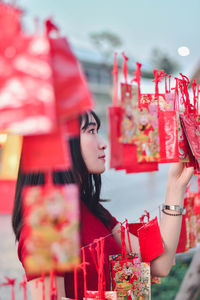 Young woman looking away while standing outdoors