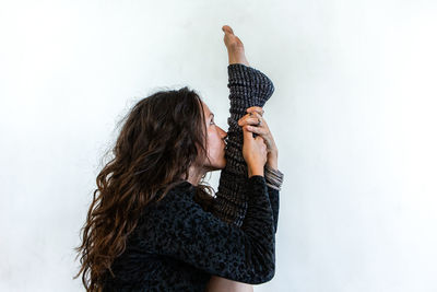 Side view of woman exercising against wall