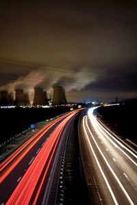 Light trails on highway against sky during sunset