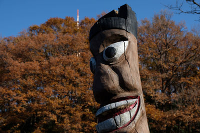 Statue by trees against sky during autumn