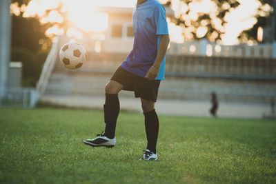 Man playing soccer ball on grass