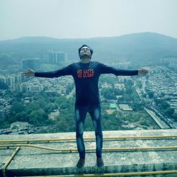 Full length of man standing on mountain in city