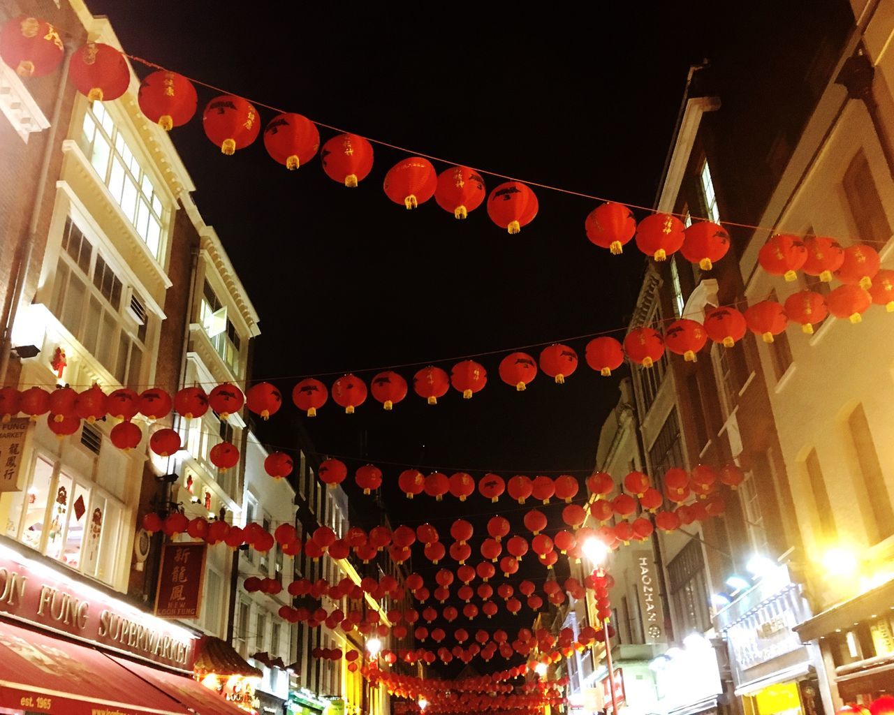 low angle view, architecture, built structure, building exterior, religion, hanging, decoration, place of worship, lantern, illuminated, spirituality, lighting equipment, temple - building, tradition, cultures, chinese lantern, red, night, roof