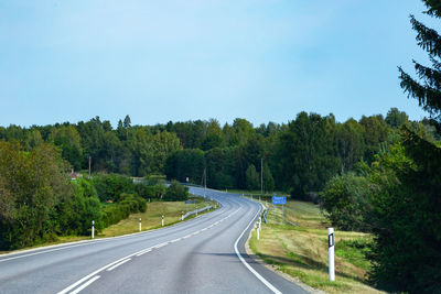 Road amidst trees against sky