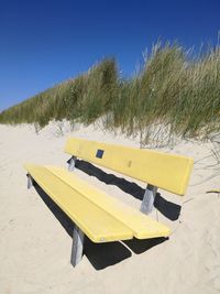 Yellow flag on beach against clear sky