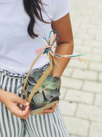 Midsection of woman holding umbrella standing outdoors
