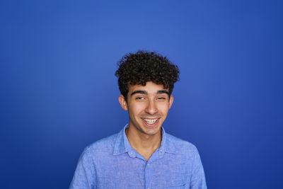 Portrait of young man against blue background