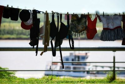 Close-up of clothes drying on clothesline against sky