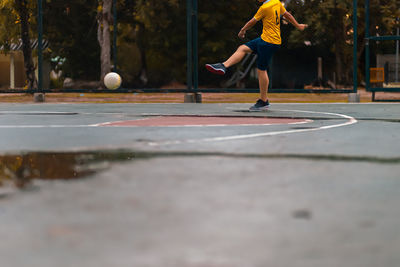 Low section of man playing football outdoors