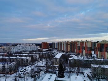 Buildings in city against sky during winter