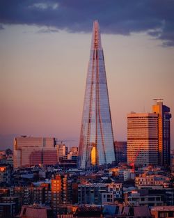 Shard london bridge amidst buildings against sky during sunset in city