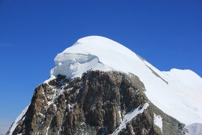 Scenic view of snowcapped mountains against clear blue sky