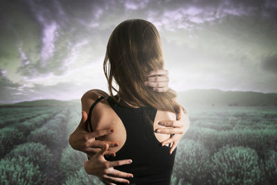 Woman standing on field against sky