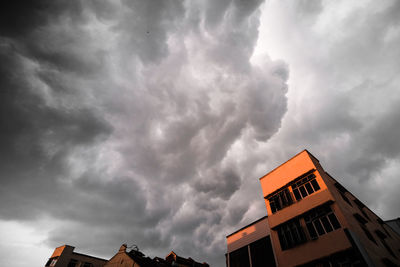 Low angle view of buildings against cloudy sky