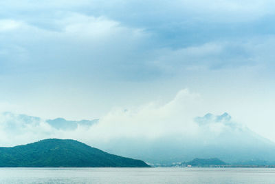 Scenic view of sea and mountains against sky