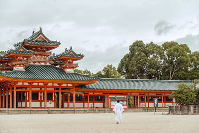 Rear view of a man walking against building