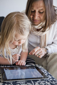 Grandmother with granddaughter using laptop