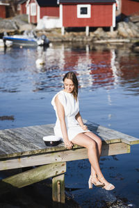 Full length of woman sitting on mobile phone