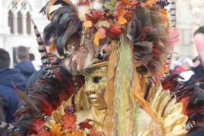 Woman wearing mask and costume at carnival in city