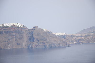 Scenic view of lake by mountains against clear sky