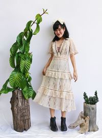Portrait of woman standing against plants