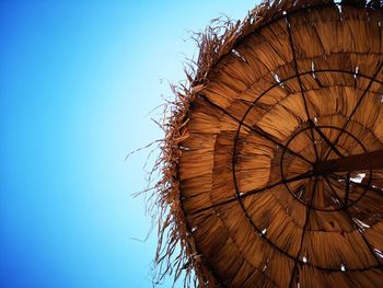 Low angle view of umbrella against clear blue sky