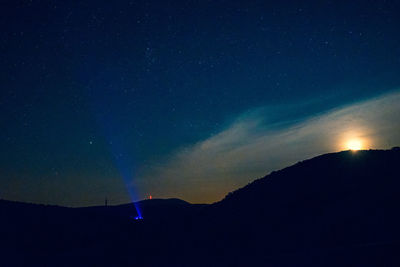 Low angle view of silhouette mountain against sky at night