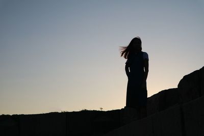 Silhouette woman standing against clear sky
