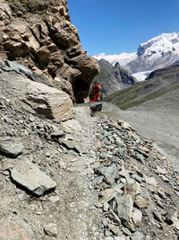 Rear view of person on rocky mountains against sky