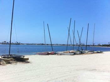 Sailboats moored in sea against sky